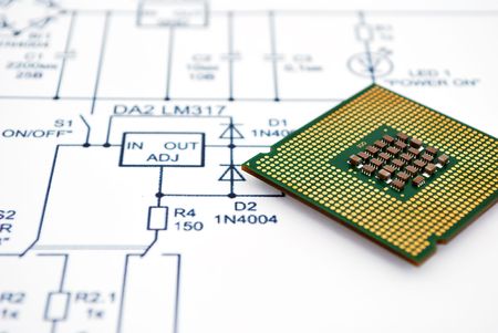 Close-up of a computer processor placed on a technical schematic diagram featuring circuit connections and component labels.