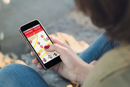 A person holding a smartphone displaying a map with marked locations.